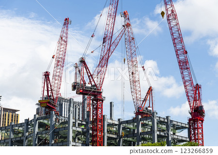 Low-angle view of cranes and steel structures of building construction with a blue sky background in Taiwan. 123266859