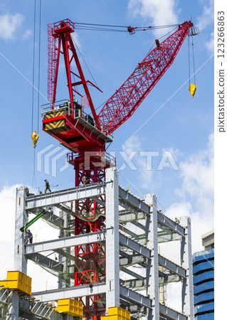 Low-angle view of cranes and steel structures of building construction with a blue sky background in Taiwan. Low-angle view of cranes and steel structures of building construction with a blue sky background in Taiwan. 123266863