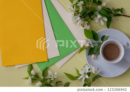 Vibrant colored paper and coffee beside fresh flowers create a serene workspace atmosphere during a creative session Vibrant colored paper and coffee beside fresh flowers create a serene workspace atmosphere during a creative session 123266942