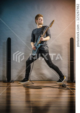 Young man playing electric guitar 123267462