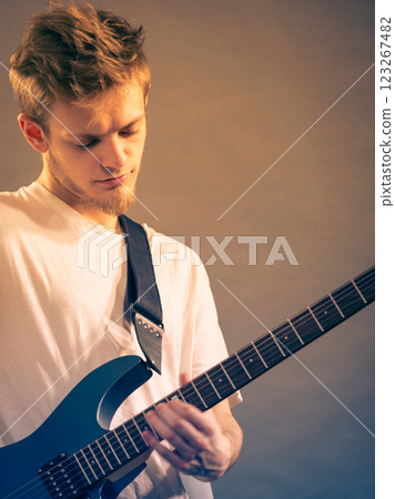 Young man playing electric guitar Young man playing electric guitar 123267482