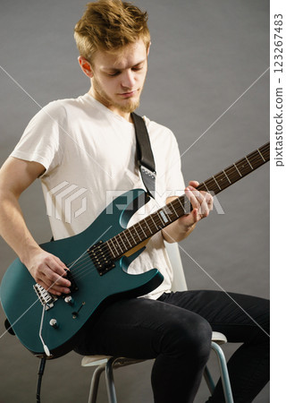 Young man playing electric guitar Young man playing electric guitar 123267483