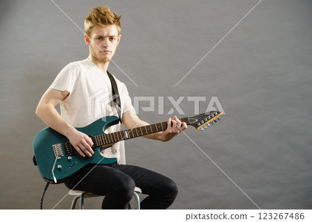 Young man playing electric guitar Young man playing electric guitar 123267486