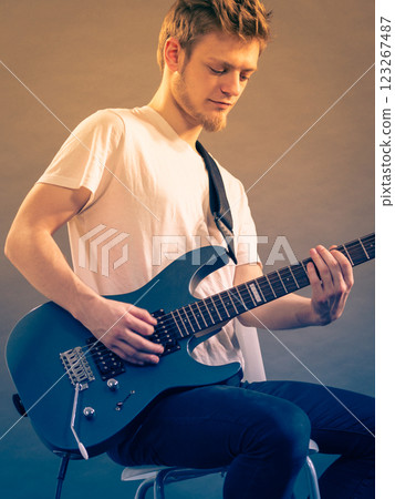 Young man playing electric guitar Young man playing electric guitar 123267487