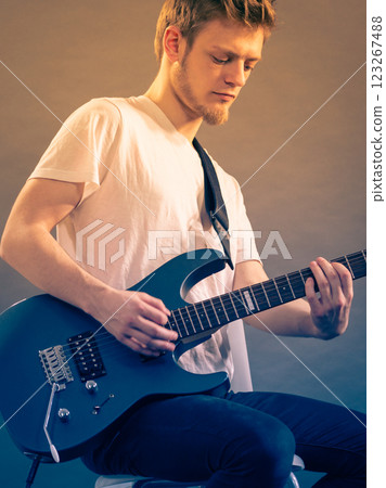 Young man playing electric guitar Young man playing electric guitar 123267488