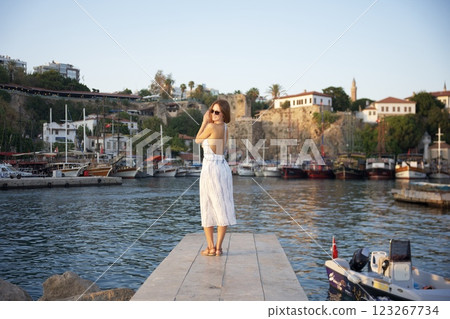 Smiling woman in backless dress at harbor Antalya, Turkey summer time 123267734