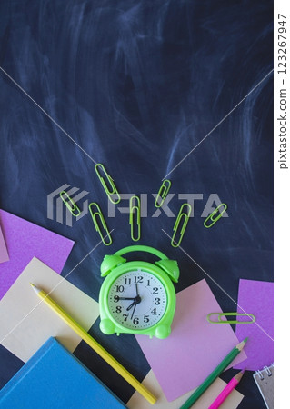Back to school concept. School supplies and alarm clock on chalkboard background with copy space, top view. Back to school concept. School supplies and alarm clock on chalkboard background with copy space, top view. 123267947