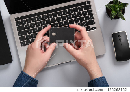 A man holds a bank card with two hands. Online payments with a credit card. 123268132
