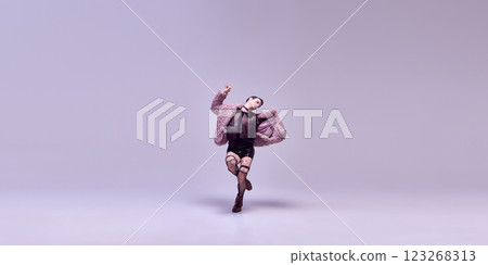 Confident model dancing in avant-garde black outfit, pose extravagantly and relaxed expression against white background. Confident model dancing in avant-garde black outfit, pose extravagantly and relaxed expression against white background. 123268313