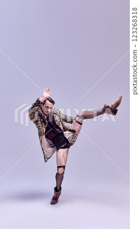 Confident man in mid-motion with bold outfit, in expressive pose, with strong gaze against stylish backdrop. Concept of beauty and fashion. Confident man in mid-motion with bold outfit, in expressive pose, with strong gaze against stylish backdrop. Concept of beauty and fashion. 123268318