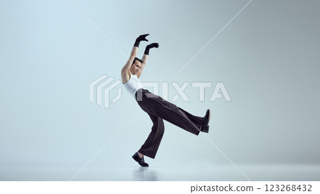 Full-length photo of young attractive man dressed fashion outfit, turning movement into art form against gradient background. 123268432