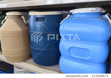 Containers lined up on a shelf with various sizes and colors for storage needs Containers lined up on a shelf with various sizes and colors for storage needs 123268615