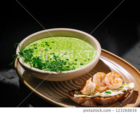 Delicious green soup served with shrimp toast in elegant setting Delicious green soup served with shrimp toast in elegant setting 123268638