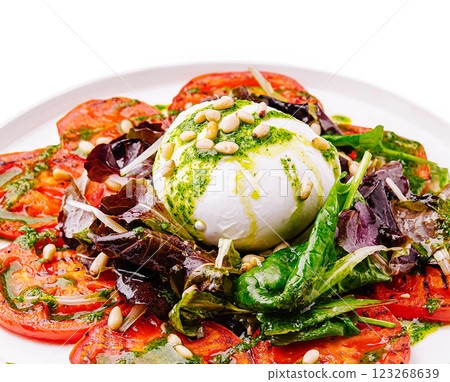 Salad with fresh tomatoes and creamy cheese on a white plate 123268639