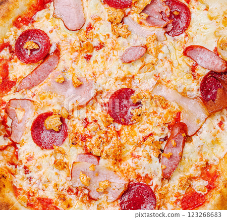 Delicious pizza topped with pepperoni and ham ready to enjoy Delicious pizza topped with pepperoni and ham ready to enjoy 123268683