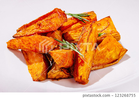 Delicious roasted sweet potatoes with herbs on a white plate Delicious roasted sweet potatoes with herbs on a white plate 123268755