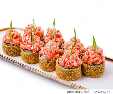 Sushi rolls topped with spicy seafood on a white platter 123268765
