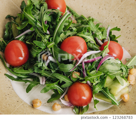 Fresh arugula and tomato salad on plate Fresh arugula and tomato salad on plate 123268783