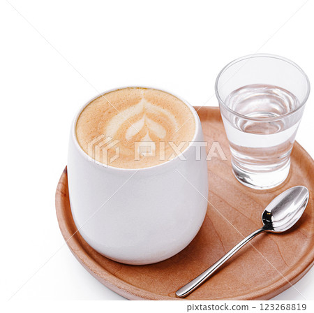 Creamy latte served with a glass of water and spoon on wooden tray 123268819