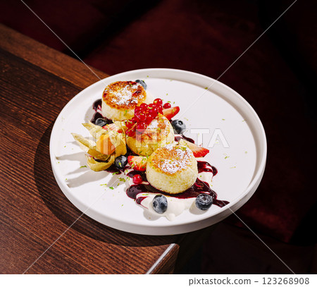 Dessert plated elegantly with fruits and berries in a cozy setting 123268908
