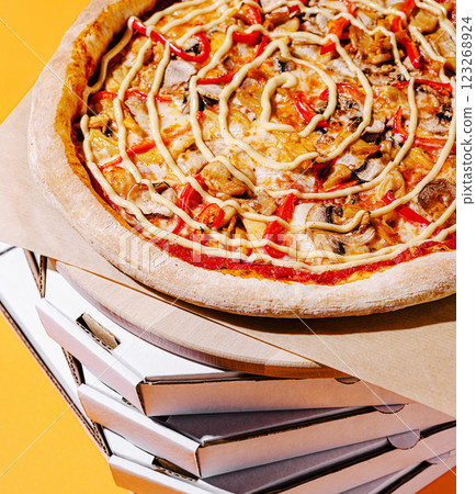 Delicious pizza topped with vegetables on a stack of boxes 123268924