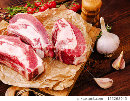 Fresh cuts of meat with garlic and tomatoes on wooden board Fresh cuts of meat with garlic and tomatoes on wooden board 123268943