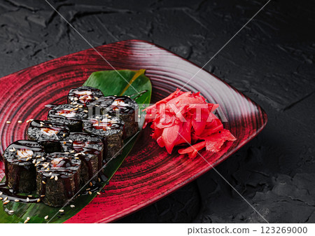 Delicious sushi rolls served with ginger on a decorative plate Delicious sushi rolls served with ginger on a decorative plate 123269000
