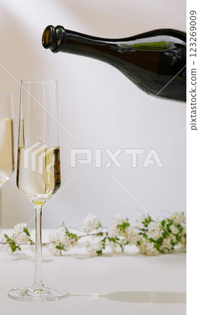 Celebratory drink being poured into a flute glass with flowers Celebratory drink being poured into a flute glass with flowers 123269009