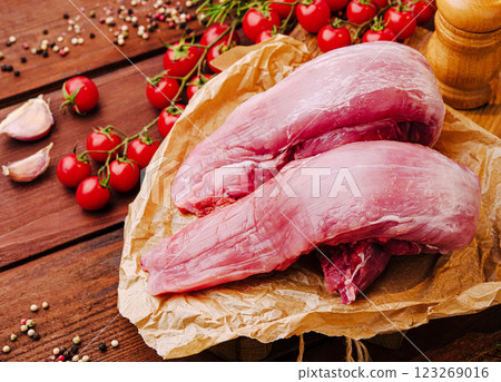 Fresh pork tenderloin with cherry tomatoes and garlic on wooden table 123269016
