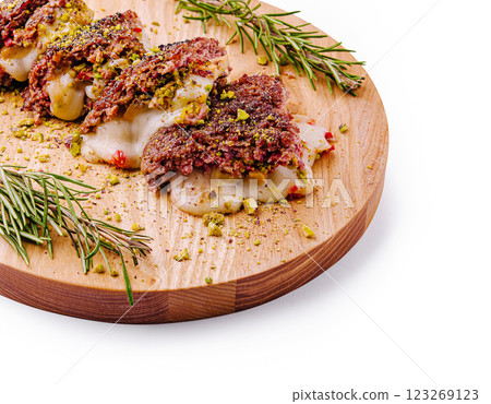 Savory meat dish with cheese and nuts on a wooden platter Savory meat dish with cheese and nuts on a wooden platter 123269123