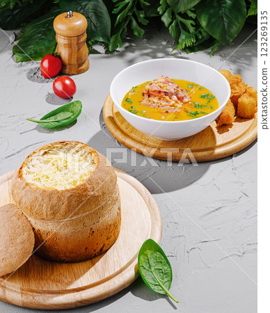 Savory soup served in bread with golden croquettes and fresh garnish 123269135
