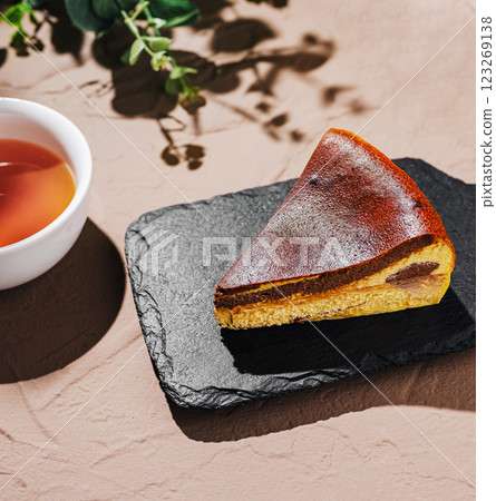 Richly flavored cheesecake served with a cup of warm tea 123269138