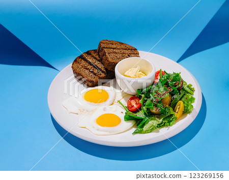 Delicious breakfast plate with eggs, salad, and bread in bright colors Delicious breakfast plate with eggs, salad, and bread in bright colors 123269156