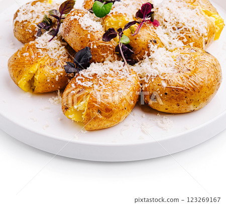 Savory baked potatoes topped with cheese and herbs on a plate 123269167