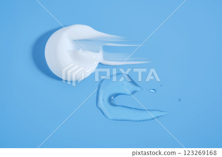 A smear of white cream And a drop of serum on a blue background. A smear of white cream And a drop of serum on a blue background. 123269168