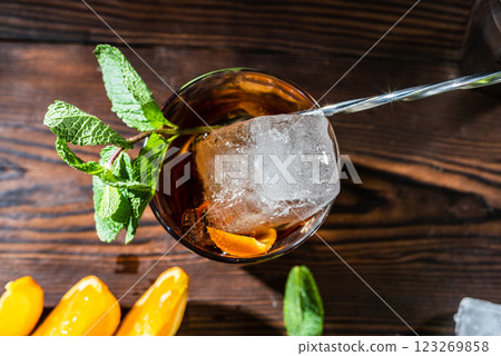 Macro photo of a piece of ice in a glass. Cocktail view from above. Bartender's spoon and ice in a cocktail. 123269858