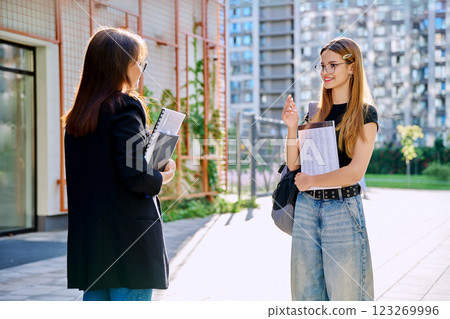 Teenage girl student talking to female teacher, outdoor Teenage girl student talking to female teacher, outdoor 123269996