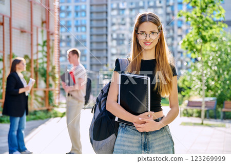 Portrait of young smiling female college student with backpack, outdoors 123269999