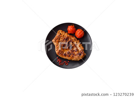 Juicy pork steak baked on the grill with salt, spices and herbs 123270239