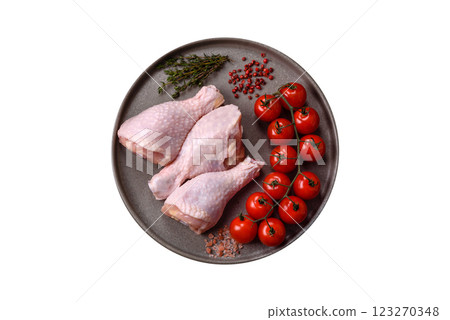 Raw chicken legs with salt, spices, herbs and tomatoes Raw chicken legs with salt, spices, herbs and tomatoes 123270348