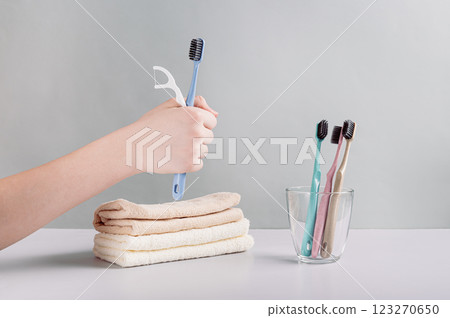 Toothbrush and dental floss in hand against background of toiletries Toothbrush and dental floss in hand against background of toiletries 123270650