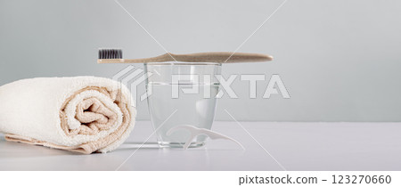 Toothbrush on a glass of water, disposable dental floss in the bathroom web banner Toothbrush on a glass of water, disposable dental floss in the bathroom web banner 123270660