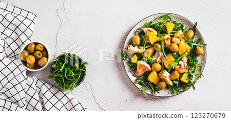 Homemade salad of cauliflower, orange, olives and greens on a plate top view web banner 123270679