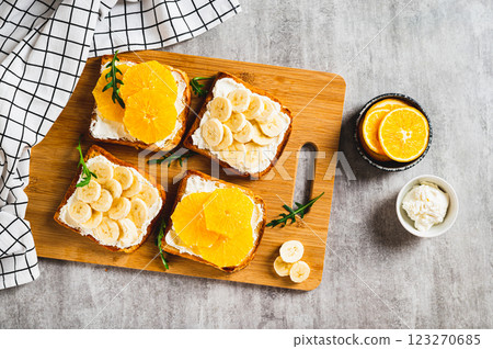 Crispy sandwiches with cottage cheese and fruits on a board on a table top view Crispy sandwiches with cottage cheese and fruits on a board on a table top view 123270685