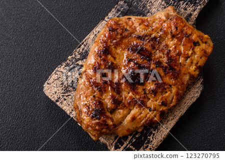 Juicy pork steak baked on the grill with salt, spices and herbs Juicy pork steak baked on the grill with salt, spices and herbs 123270795