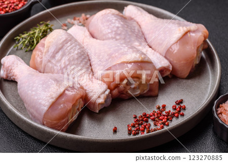 Raw chicken legs with salt, spices and herbs 123270885