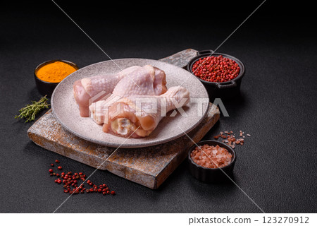 Raw chicken legs with salt, spices and herbs 123270912
