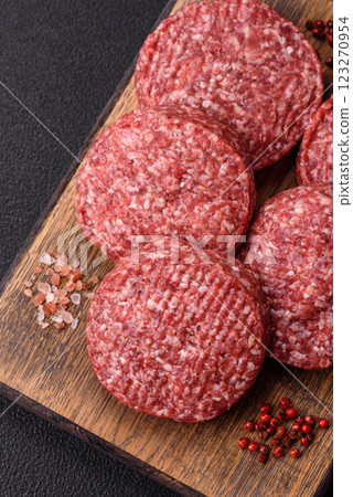 Fresh raw ground beef burger patty with salt and spices Fresh raw ground beef burger patty with salt and spices 123270954