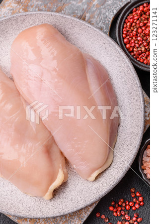 Pieces of raw chicken or turkey fillet with salt, spices and herbs 123271141