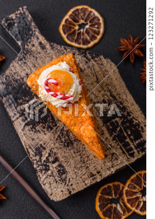 Piece of sweet layer cake with pumpkin or citrus flavor with cream 123271292